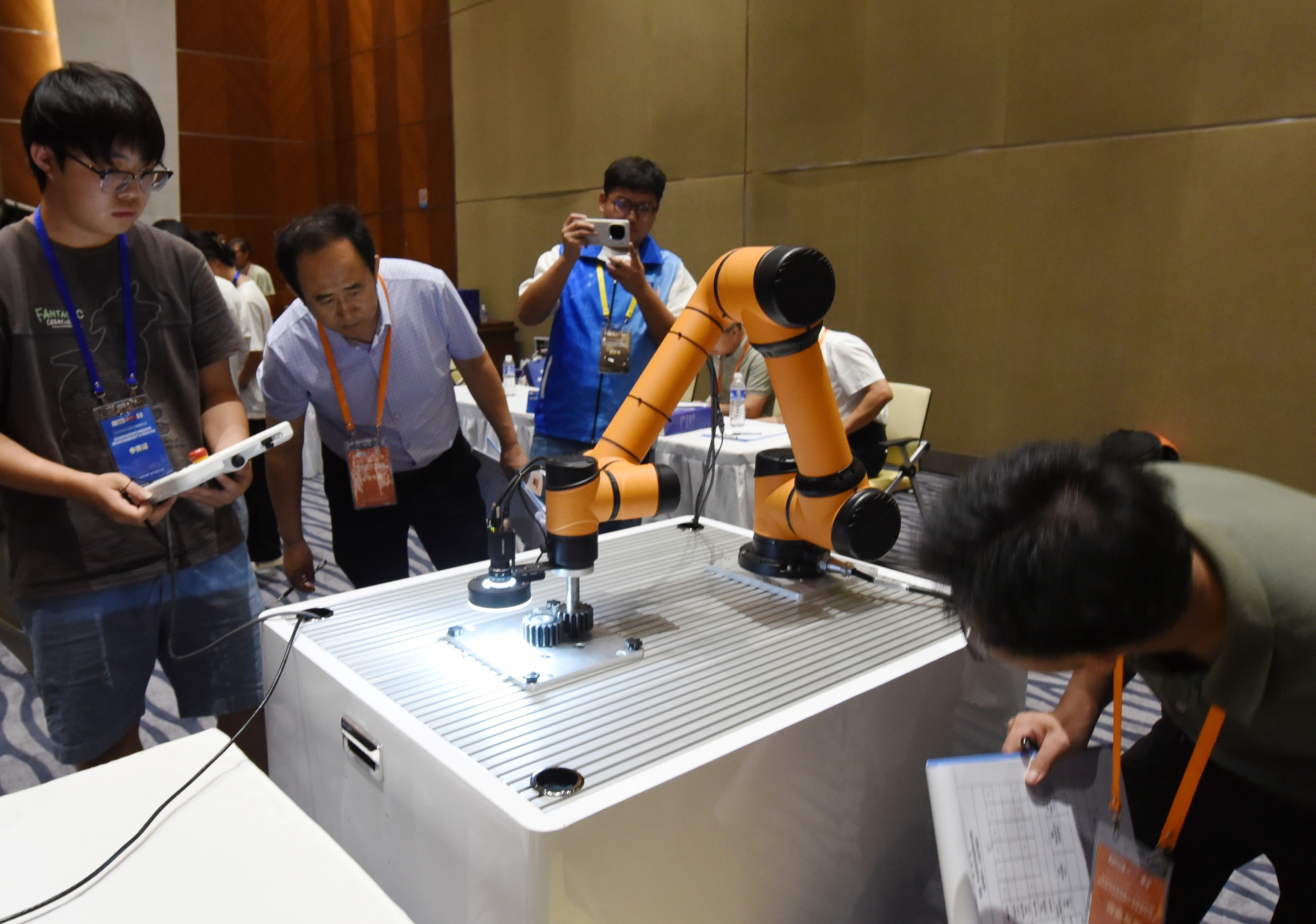 2025年中國大學(xué)生機(jī)械工程創(chuàng)新創(chuàng)意大賽智能精密裝配賽京津冀魯聯(lián)賽現(xiàn)場(chǎng)，評(píng)委對(duì)參賽選手進(jìn)行實(shí)操調(diào)試評(píng)比。